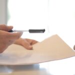 person handing paperwork to another person