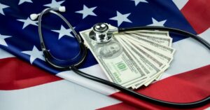 american flag with money and a stethoscope
