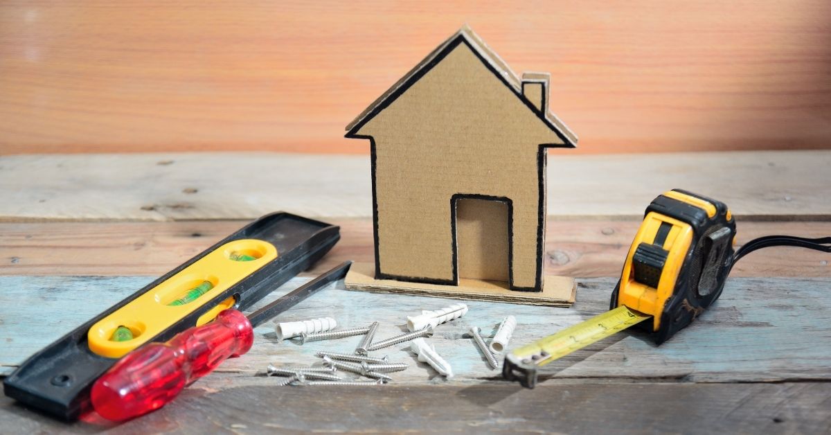 cardboard house with screws wall anchors and tools