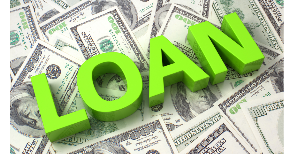 The word LOAN written out in big, bright green letters laying across a pile of 100-dollar bills. This indicates that this piece is about loans and advances and how they work.