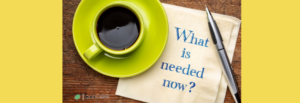 A yellow cup and saucer with coffee sits atop a napkin that has "What is needed now?" typed on it in a blue serif font. This implies that the article relates to how "I need money right now, what should I do?"