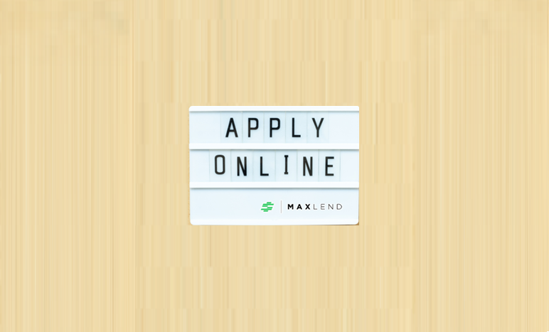 A white sign that says "APPLY ONLINE" in capital letters and has the MaxLend logo on the bottom corner of is on top of a beige-colored background. This indicates that the blog is about Applying for a Loan With MaxLend.