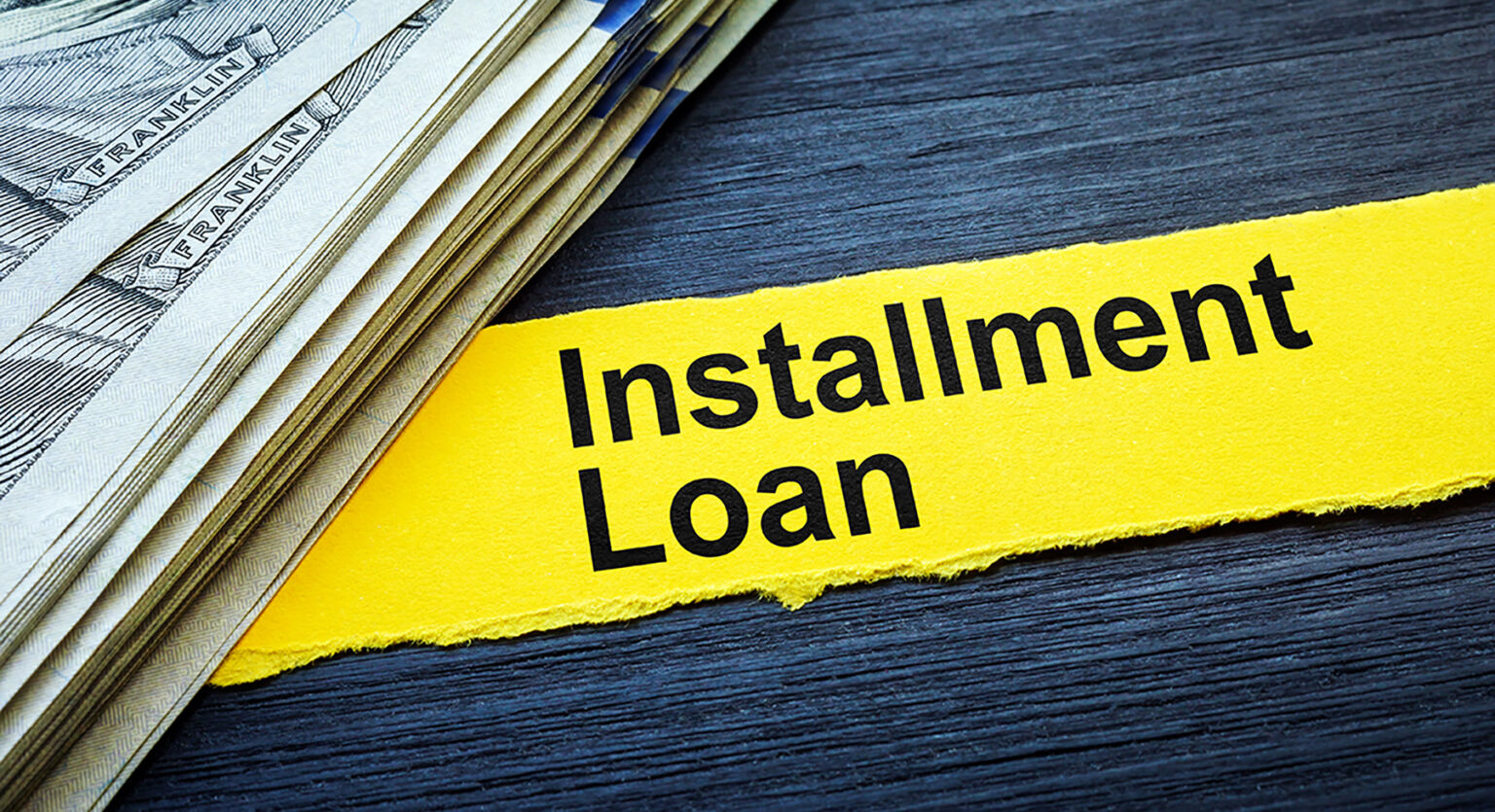 A stack of $100 bills sits on a table. The picture is labeled “Installment Loan.”